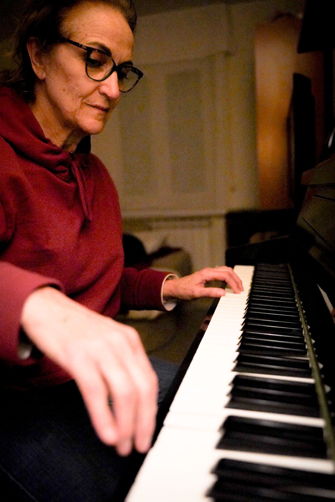 Piano en casa Mujer tocando el piano en una habitación iluminada